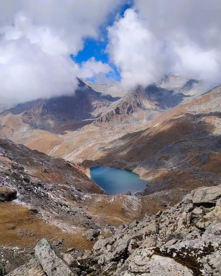 Emerald lake of Vasuki tal shadowed by clouds